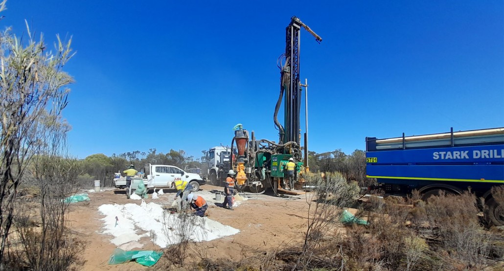 Figure 1. Stark Drilling Rig 1 set up at the Boomerang Prospect showing kaolin clays in sample piles.